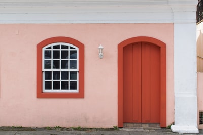 Pink concrete houses, orange wood door closed
